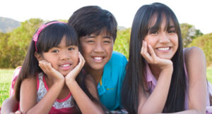 three smiling kids/teens